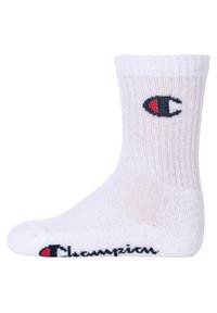 Calzino sportivo bianco, texture a coste, bordo ripiegato, presenta un piccolo logo nero e rosso sul lato e la scritta "Champion" in blu navy sulla punta.