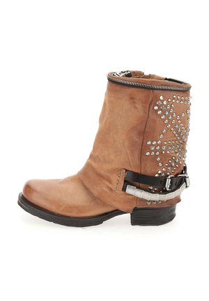 Bottine en cuir marron avec fermeture éclair sur le côté, design clouté sur le côté extérieur et une sangle avec des accents métalliques. Semelle plate.