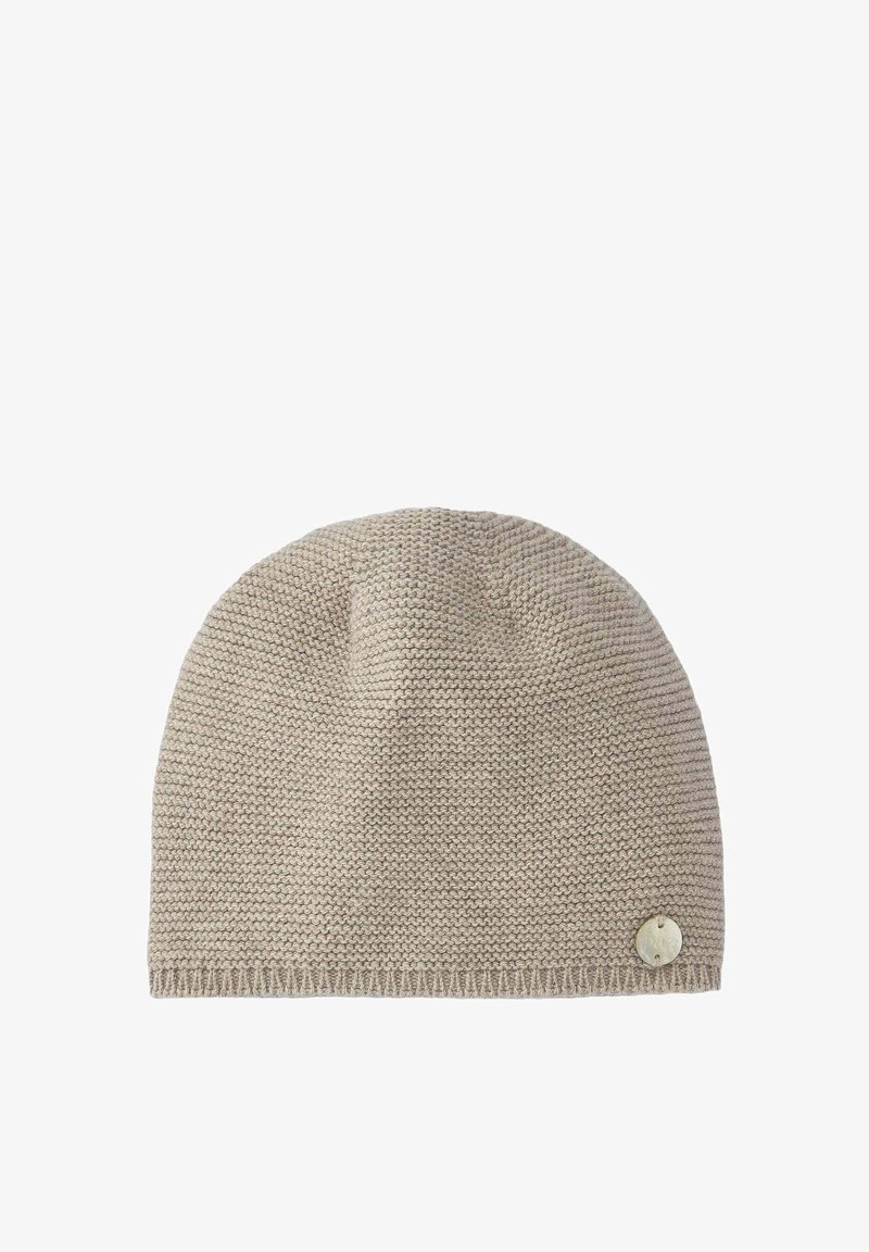 Bonnet tricoté en beige clair avec un motif texturé, comportant un accent logo en métal rond sur le côté et un bord côtelé.