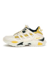 Sneaker bianco e giallo con tomaia in mesh traspirante, colletto imbottito e suola spessa con accenti neri e gialli. Logo del marchio visibile.