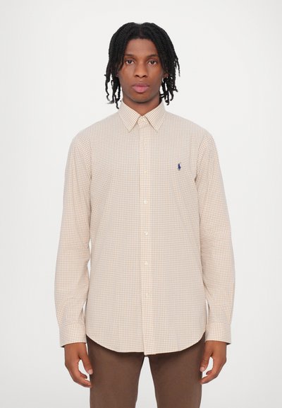 Rutete skjorte i beige og brunt med lange ermer, knepping-krage og marineblå logo på brystet. Glatt bomullsstoff.