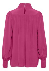 Fuchsia-blus med långa, puffade ärmar. Plisserad design på baksidan med hög halsringning och knäppning. Texturerade manschetter.