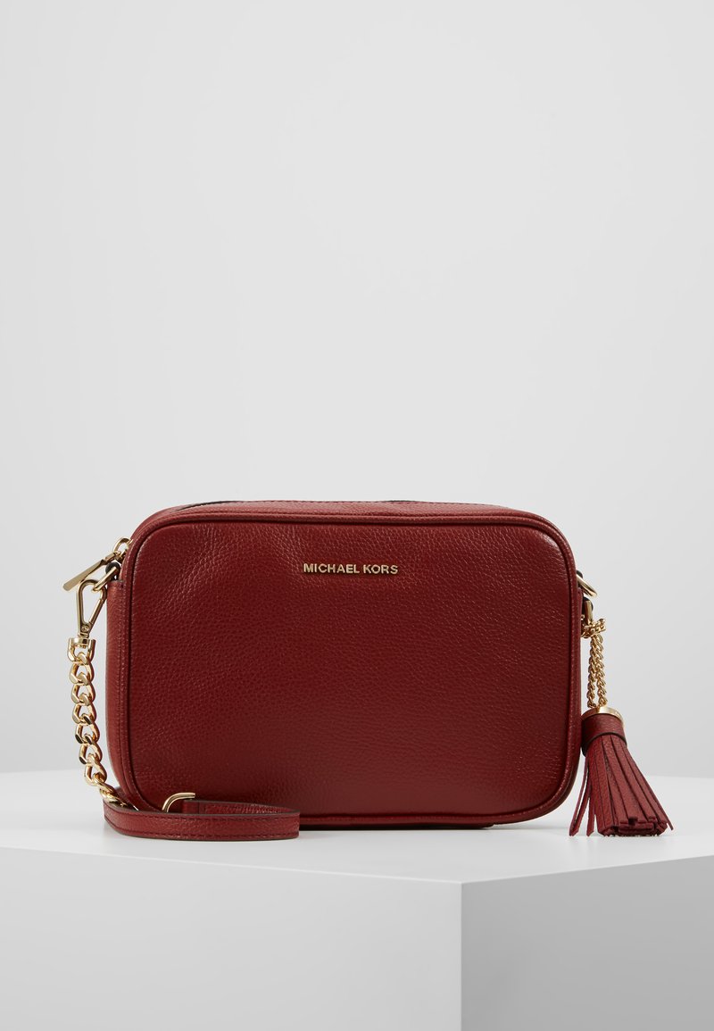 Rote Leder-Crossbody-Tasche mit goldfarbenen Beschlägen, Quastenakzent und geprägtem Markenlogo. Rechteckige Form mit abnehmbarem Tragegurt.