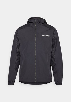 Čierna bunda Terrex s kapucňou, zipsom a vzorovanými rukávmi. Vyrobená z ľahkého materiálu s elastickými manžetami a rovnými okrajmi.