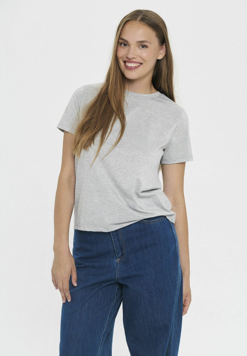 Szara koszulka z krótkim rękawem o luźnym kroju, zestawiona z wysokim stanem ciemnoniebieskich dżinsów o klasycznej strukturzedenimu.