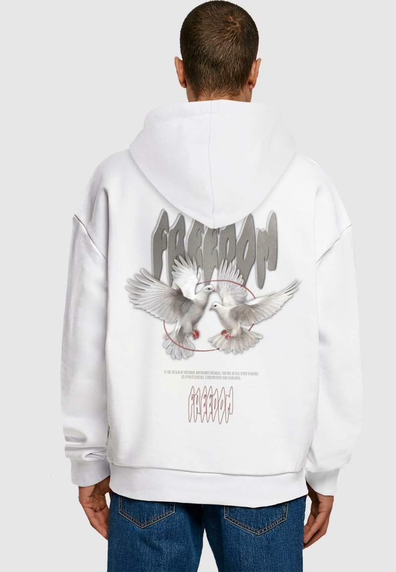 Hvid hoodie med et grafisk print af to duer og ordet "FREEDOM" i grå. Stoffer ser blødt ud med en afslappet pasform.
