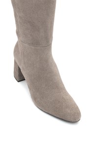 Zamszowe botki za kostkę w jasnoszarym kolorze, z wysmuklonym noskiem i szerokim obcasem. Gładka tekstura z subtelnymi detalami przeszycia.