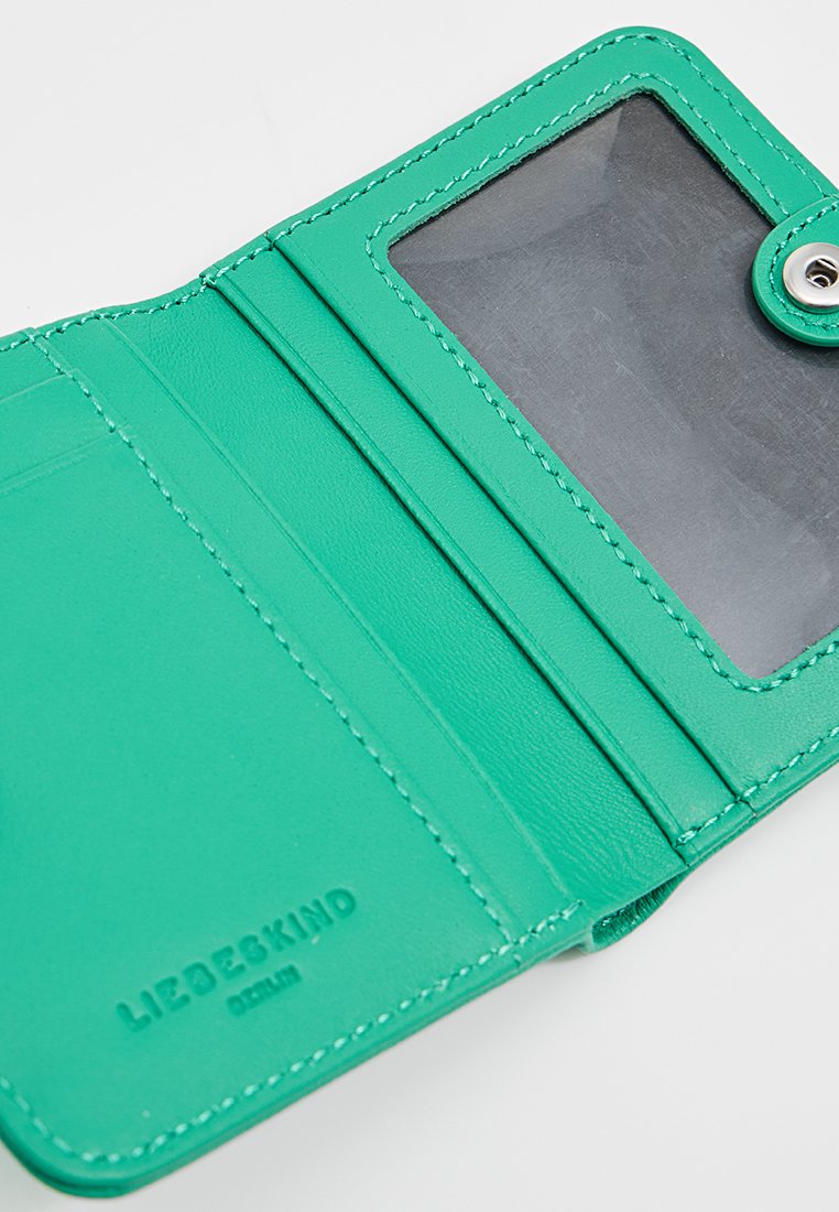 Grünes Lederportemonnaie mit einem klaren Ausweisfenster und mehreren Kartenfächern. Verfügt über gestickte Details und ein geprägtes Markenlogo. Kompaktes Design.