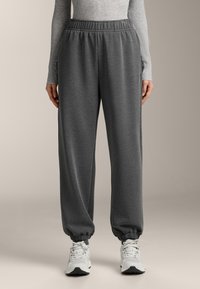 Szürke melegítőalsó rugalmas derékpánttal, szűkített szárvégekkel és oldalzsebekkel. Puha, texturált anyagból készült, alkalmi viselésre alkalmas.