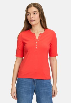 Top rosso a maniche corte con scollatura henley, caratterizzato da cinque bottoni decorativi. Realizzato in un materiale liscio con un design aderente.