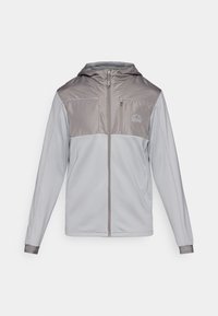 Jakna s kapuljačom u svijetlo sivoj boji s tamnijim sivim naglascima; ima cijeli patentni zatvarač, duge rukave i logo na gornjoj lijevoj strani.