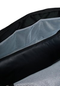 Interno di una borsa di tessuto nero con tasche e divisori in rete grigia. Rivestimento interno liscio, chiusura con zip e molteplici scomparti per l'organizzazione.