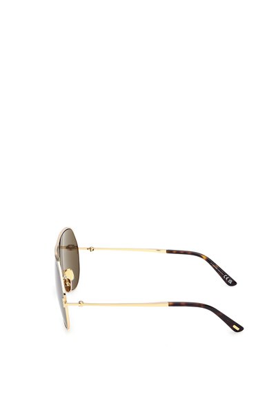 Zlaté sluneční brýle s oválnými tmavými skly, s designem želvoviny na stranách a jemným logem na vnitřní straně ramena.