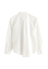 Biała koszula z długim rękawem, z kołnierzykiem zapinanym na guziki, detalem w postaci plisy z tyłu oraz z zapięciem na guziki przy mankietach; wykonana z miękkiego materiału o gładkiej fakturze.
