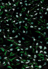 Schwarzer Stoff mit einer glatten Textur, der ein florales Muster aus weißen Knospen und grünen Stängeln auf einem dunklen Hintergrund zeigt.