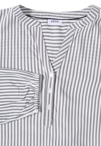Chemise à boutons en rayures blanches et grises, avec un col en V, des manches longues avec des poignets froncés et une petite poche poitrine.
