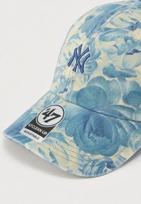 Βαμβακερό καπέλο μπέιζμπολ με μπλε και κρεμ λουλουδάτο σχέδιο, κεντημένο λογότυπο NY σε ναυτικό χρώμα και ρυθμιζόμενο λουράκι για άριστη εφαρμογή.