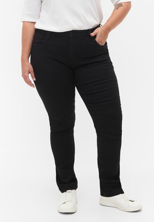 Black slim-fit jeans with front pockets, a button closure, and belt loops, paired with white sneakers, against a plain white background.