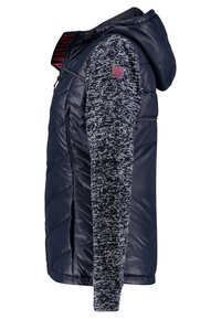 Granatowa kamizelka puchowa z teksturowanym rękawem dzianinowym, z kapturem, zamkiem błyskawicznym z przodu i naszywką z logo. Korpus jest błyszczący i pikowany, zapewniający ciepło.