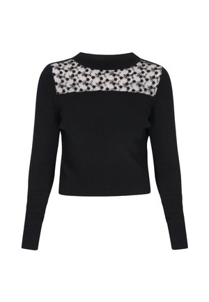 Haut noir à manches longues en tissu côtelé avec un panneau transparent en dentelle florale noire sur la partie supérieure de la poitrine et les épaules.
