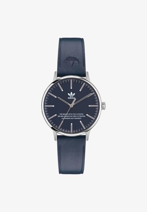 Herenhorloge met een ronde zilveren stalen kast, marineblauwe leren band, minimalistische wijzerplaat, zilveren uurmarkeringen en Adidas-logo.