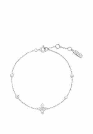 Fin sølvarmbånd med fem små runde krystaller og en blomstformet krystalgruppe i midten, justerbar lås med mærke.