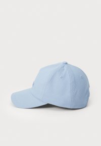 Lyseblå baseballcaps i stoff, med en buet skjerm og ventilasjonshull på siden, samt en brodert logo foran.