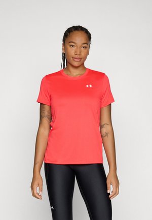 Camiseta atlética roja con mangas cortas, cuello redondo y detalle de logotipo. Tejido suave y ligero. Combinada con leggings negros.