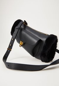 Borsa a tracolla in pelle nera con finitura texture, bordino in pelliccia sulla parte superiore, hardware della cerniera in oro e tracolla regolabile. Design compatto e strutturato.