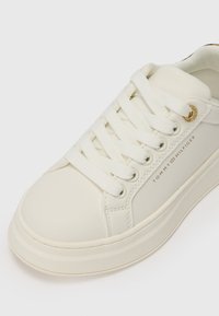 Hvite sneakers med glatt lærøvre, rund tå, flate lisser og en subtil logo detalj. Har en teksturert såle for grep.