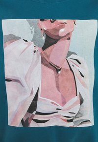 Tyrkysová mikina s pastelovým motivem postavy s perlovými náušnicemi a vzorovanou blůzou, zdůrazňující geometrické tvary a tlumené barvy.