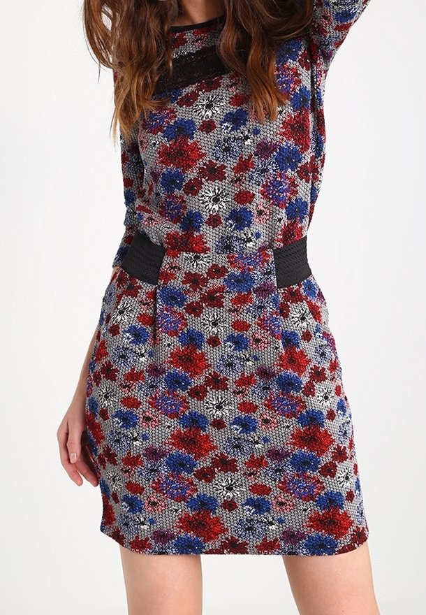 Jurk met bloemenpatroon in rood, blauw en zwart. Getailleerd ontwerp met een gestructureerde stof en een zwarte tailleband. Korte mouwen.