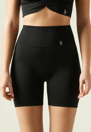 High-waisted black shorts made of stretchy fabric, featuring a smooth texture and a logo tag on the waistband.