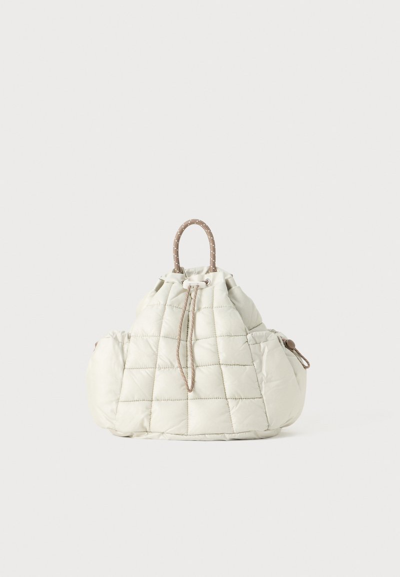 Saco em creme acolchoado com fecho de cordão e duas alças texturizadas. Apresenta um design fofinho e suave, com discretos detalhes em marrom nas alças.
