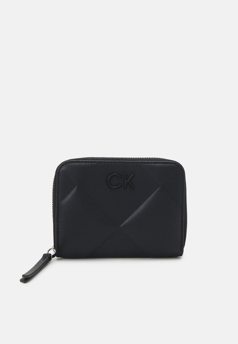 Black quilted wallet made of smooth material, featuring embossed "CK" logo, a zip closure, and a leather pull tab. Rectangular shape.