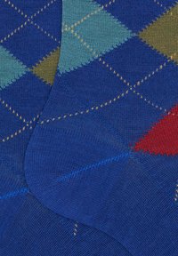 Calze blu con motivo a rombi argyle nei toni del celeste, verde, marrone e rosso. Texture liscia e dettagli di cuciture gialle visibili.