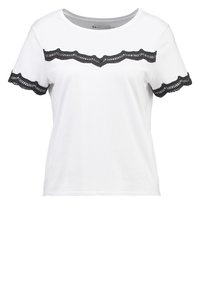 Camisa blanca de manga corta con cuello redondo, que presenta detalles de encaje negro en el pecho y los bordes de las mangas.