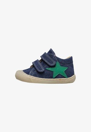 Chaussure en denim bleu avec deux bandes Velcro, accent étoile verte sur le côté et un capuchon en caoutchouc à l'avant. Caractéristiques d'une semelle texturée pour une meilleure adhérence.