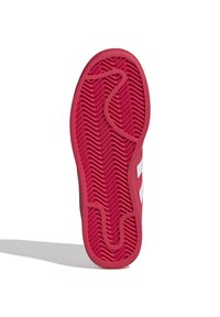 Röd sneakersula med fiskbensmönster och ett löst snöre på vit bakgrund med delvis synliga sidostråkar.