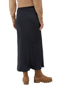 Tmavě modrá maxi sukně s hladkou texturou a elastickým pasem, doplněná o hnědé kotníkové boty.