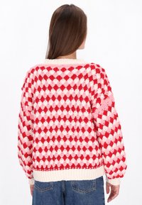 Crochet sweater featuring a diamond pattern in pink and red, with a crew neckline, ribbed cuffs, and a relaxed fit.