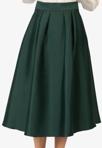 Een groene midi-rok met een gladde satijnen afwerking, voorzien van scherpe plooien en een aansluitende tailleband, die in een A-lijnvorm valt.