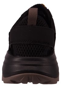 Czarne buty sportowe z siateczkową cholewką, regulowanym paskiem oraz gumową podeszwą z teksturowanym bieżnikiem dla lepszej przyczepności. Tylny uchwyt umożliwiający łatwe zakładanie.