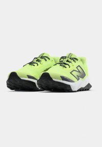Lime green running shoes with mesh upper, black and white speckled midsole, and rugged black outsole. Features reinforced toe cap and laces.