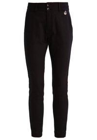 Svarta figurnära ankellånga byxor med två framknappar, bältesöglor och en liten silverfärgad märkesetikett nära midjan.