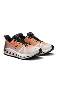 Scarpe da corsa con un upper in mesh traspirante in gradiente arancione e bianco, con dettagli blu navy e una suola imbottita.