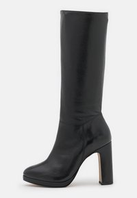 Botte noire en cuir montant jusqu'au genou, dotée d'un bout arrondi et d'un talon haut épais. Texture lisse avec des détails de couture minimaux.