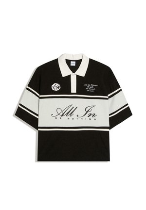 Čierno-biela košeľa s golierom a horizontálnymi pruhmi, s logom kocky a textom „All In Or Nothing“ a malou frázou na hrudi.