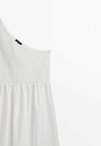 Abito bianco a spalla unica con corpetto arricciato e gonna fluida, realizzato in tessuto leggero, con una texture liscia e dettagli minimi.