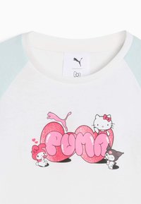Biała koszula z jasnoniebieskimi rękawami, ozdobiona różowym, błyszczącym napisem "PUMA", logo Pumy oraz postaciami Hello Kitty: My Melody i Kuromi.
